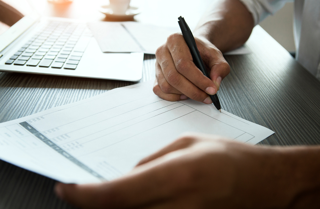 A person with a pen looking at a billing statement.