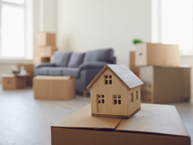 moving boxes with a wooden house on top of a box