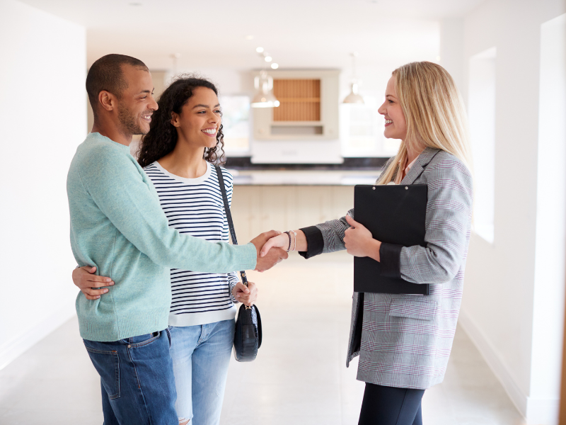 couple shaking hands with a Realtor