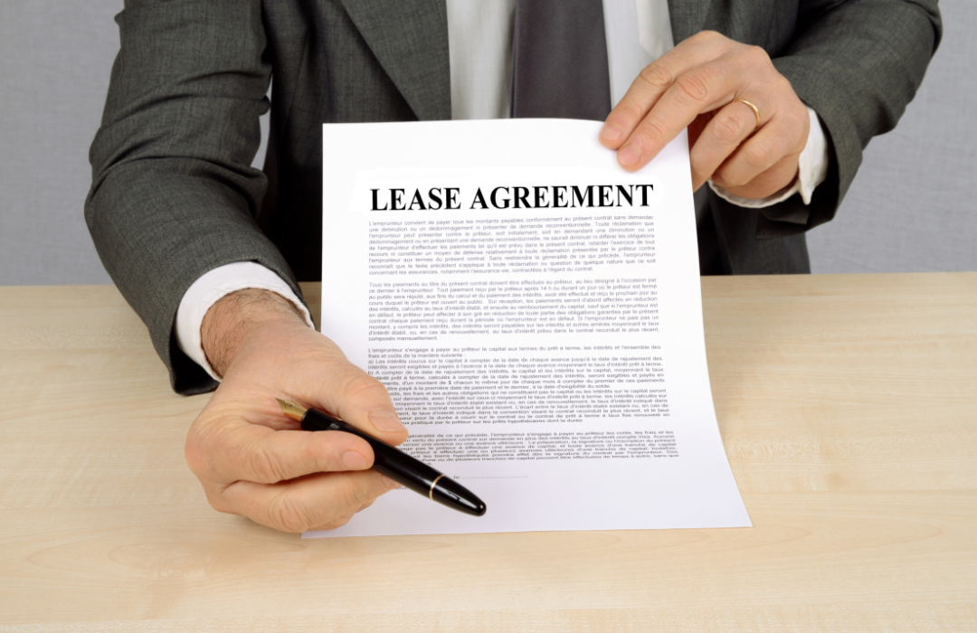 Man Holding Up a Lease Agreement.