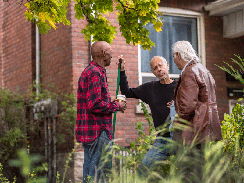 Older male neighbors talking with each other.