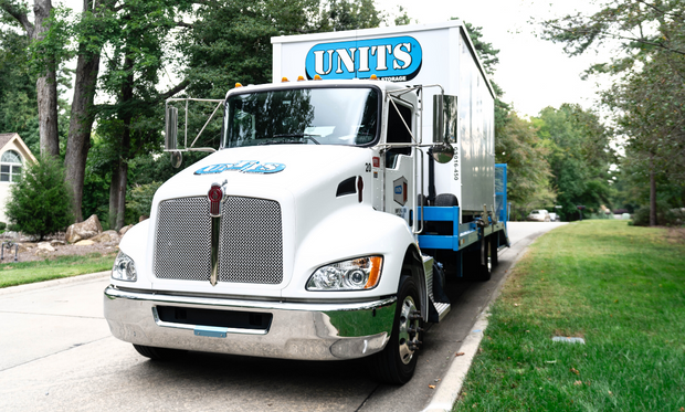 UNITS Moving and Portable Storage truck carrying a storage container.