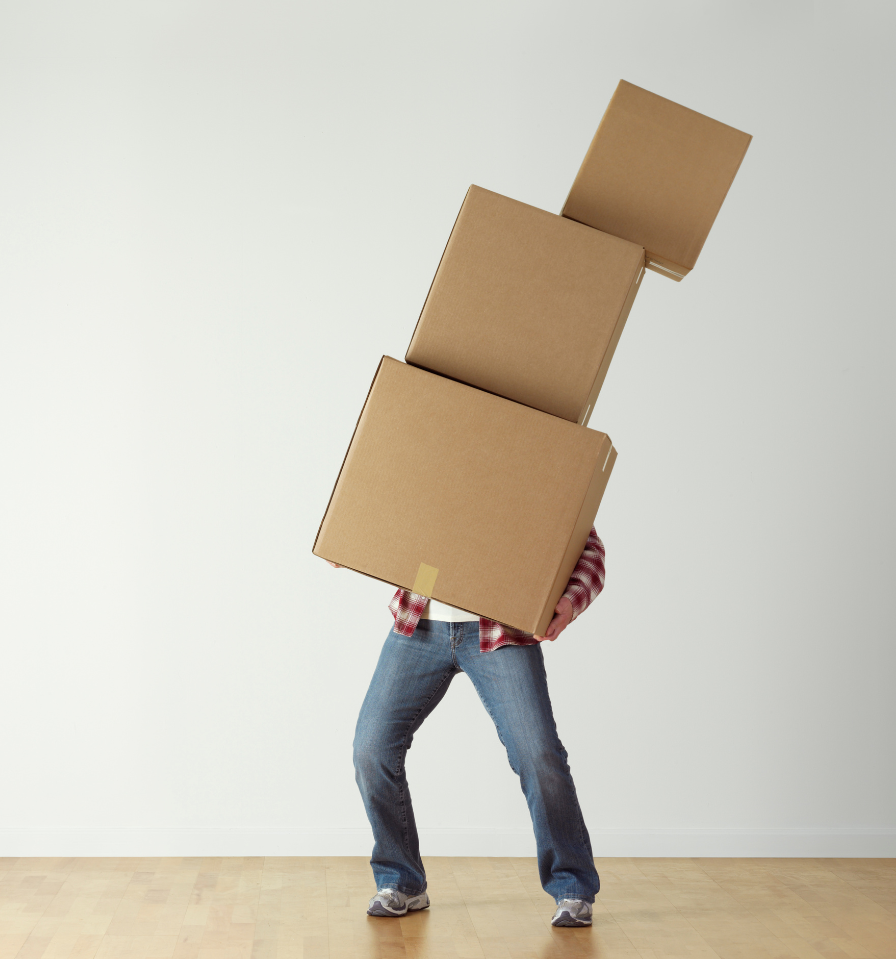 Man holding up several cardboard boxes stacked on top of each other struggling to hold them up as they begin to tip over.