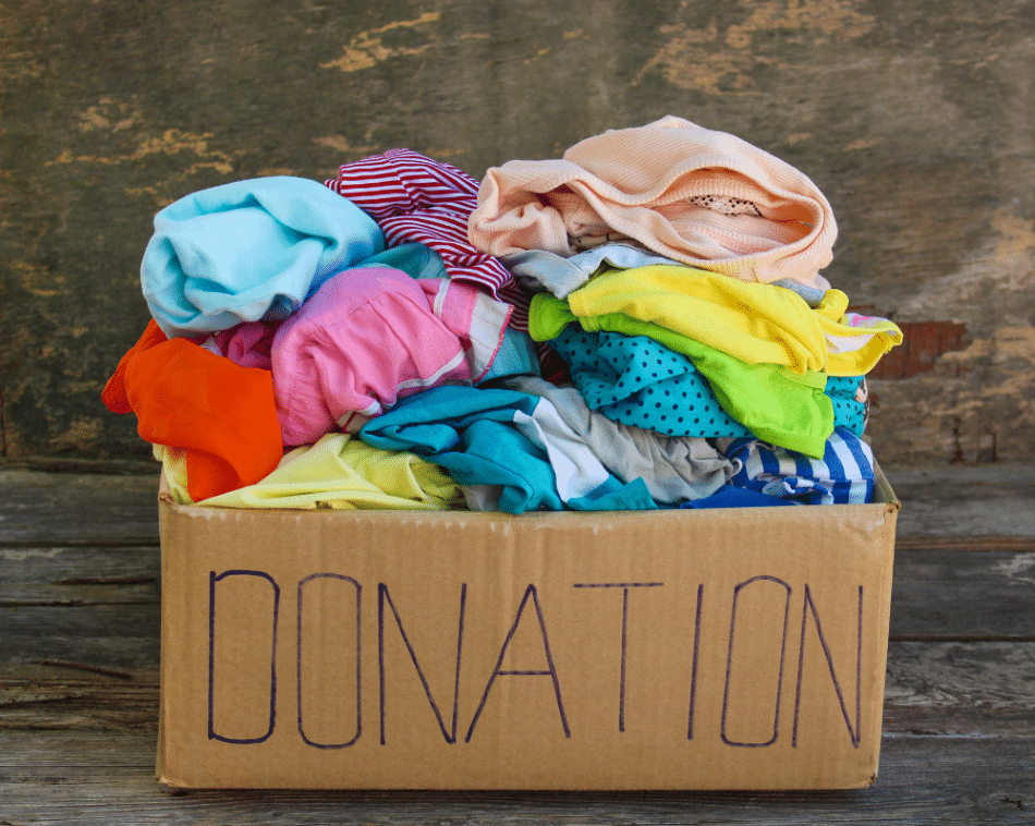 Clothes in a cardboard box with donation written on it.