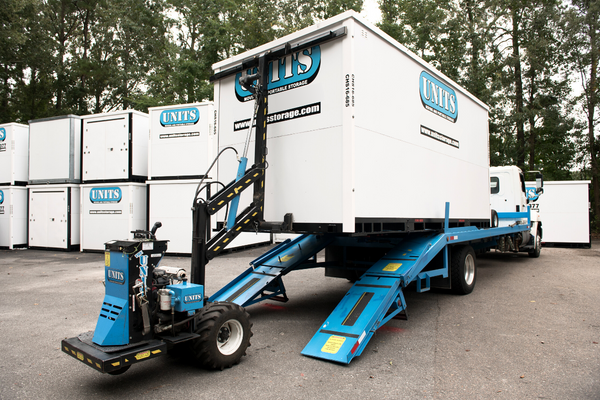 ROBO-UNIT moving a UNITS Moving and Portable Storage container off a truck.