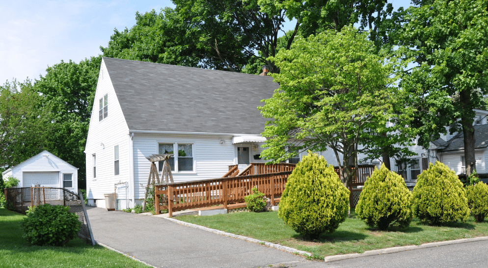 Trees and shrubbery in front of a house.