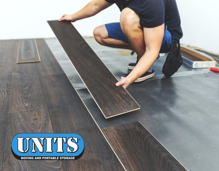 A man putting down hardwood floor with UNITS logo