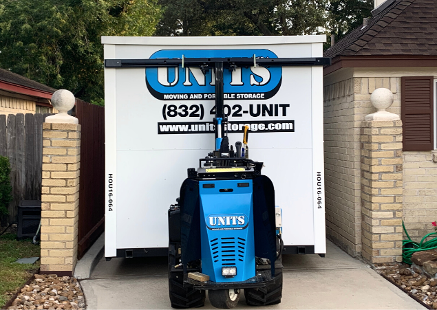 A Units of Houston Gulf Coast container sitting in the driveway of a house.