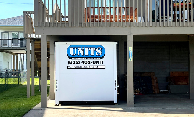 A Units of Houston Gulf Coast container sitting under a porch.