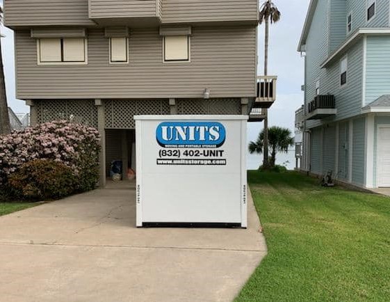 A Units of Houston Gulf Coast container sitting in the driveway of a house.