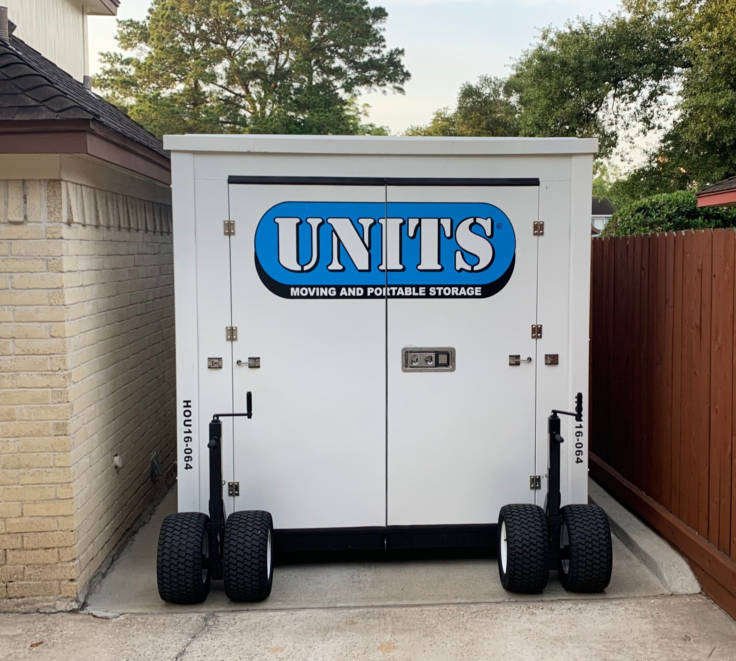 A Units of Houston Gulf Coast container in a driveway.