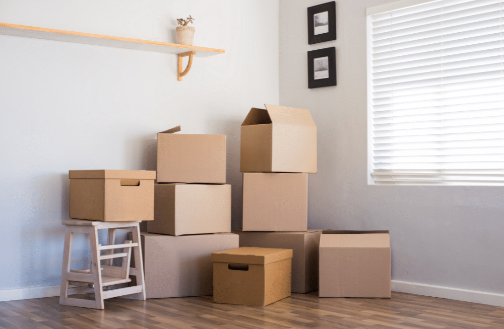 Cardboard boxes stacked in the corner of a room.