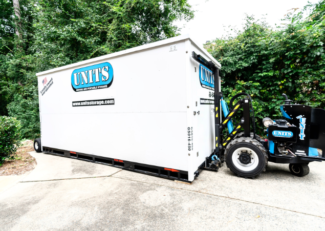 ROBO-UNIT moving a UNITS Moving and Portable Storage container in a driveway.