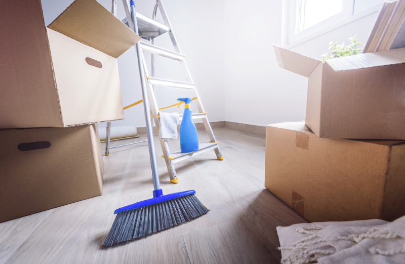 Cleaning supplies on the floor amongst cardboard boxes.