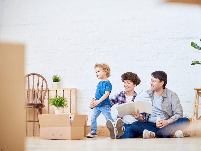 Couple going through a binder while sitting on the floor with their kids.