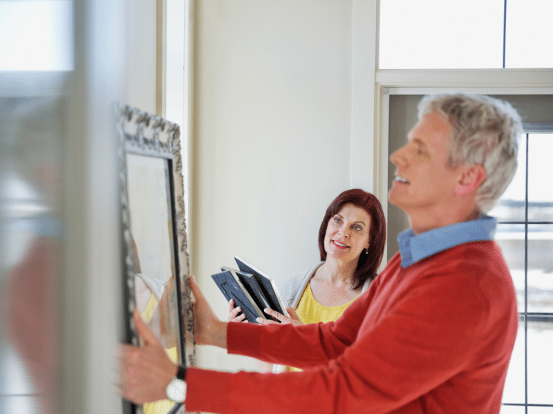 Man and woman packing framed photos.