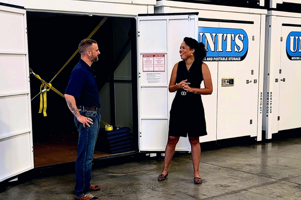 A man and a woman standing in front of Units of Kansas City containers.