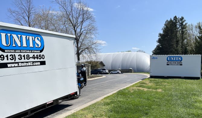 Two Units of Kansas City container sitting in a parking lot.