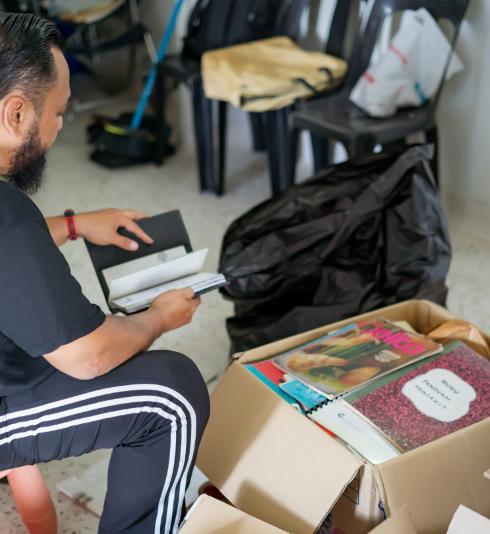 A man packing books into cardboard boxes.