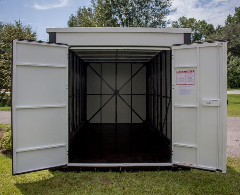 A container on the ground with both its doors open.