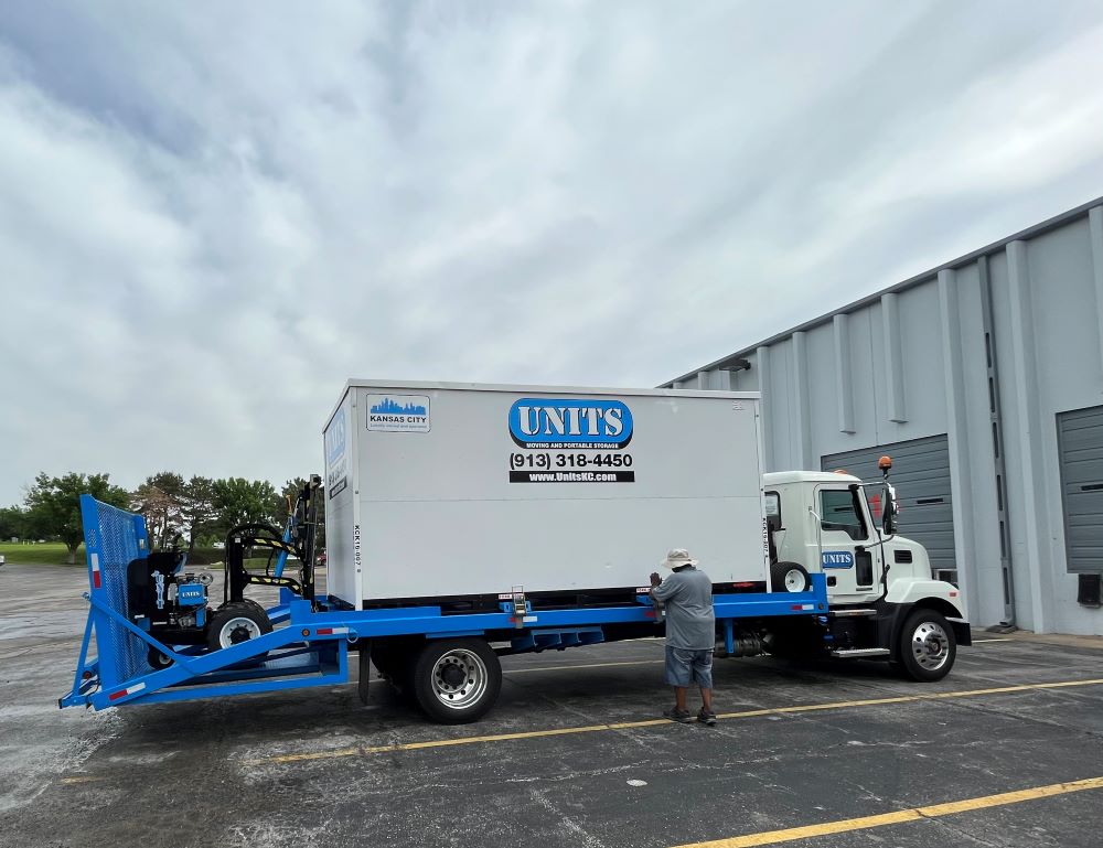 A man standing in front of a Units of Kansas City truck.