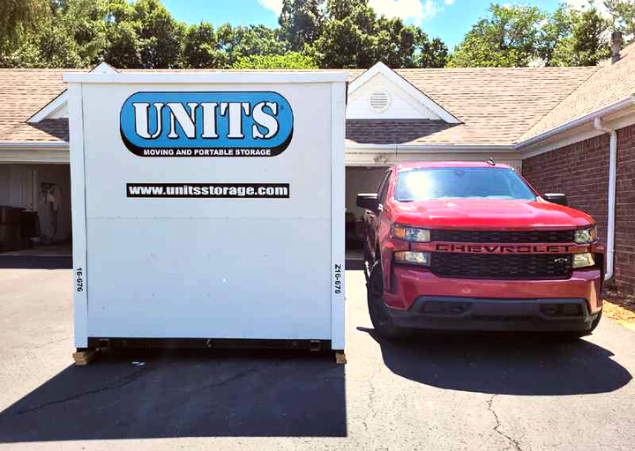 A Units Of Lexington Kentucky container sitting in the driveway of a house.