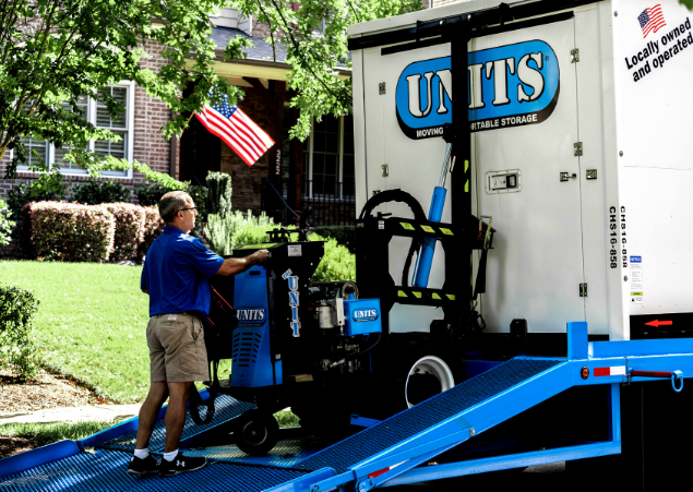 A man loaded a Units Of Lexington Kentucky container onto a truck.