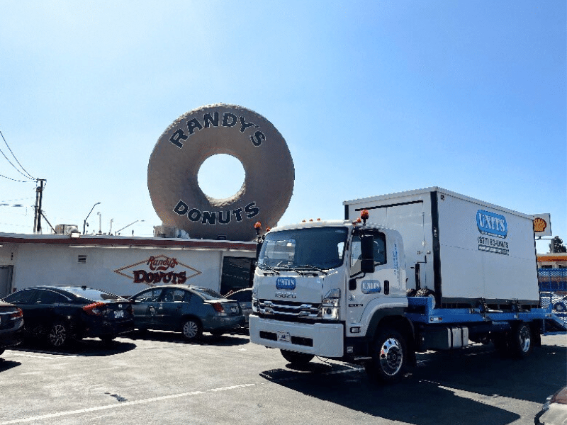 UNITS Moving and Portable Storage container on the back of a truck in front of Randy's Donuts.