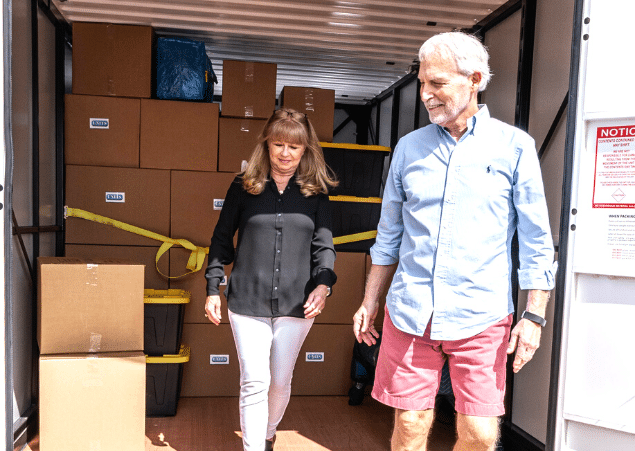 Man and woman exiting a portable storage container.