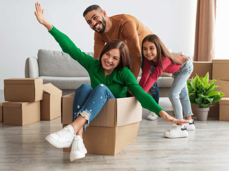 Dad and daughter pushing mom in a cardboard box.