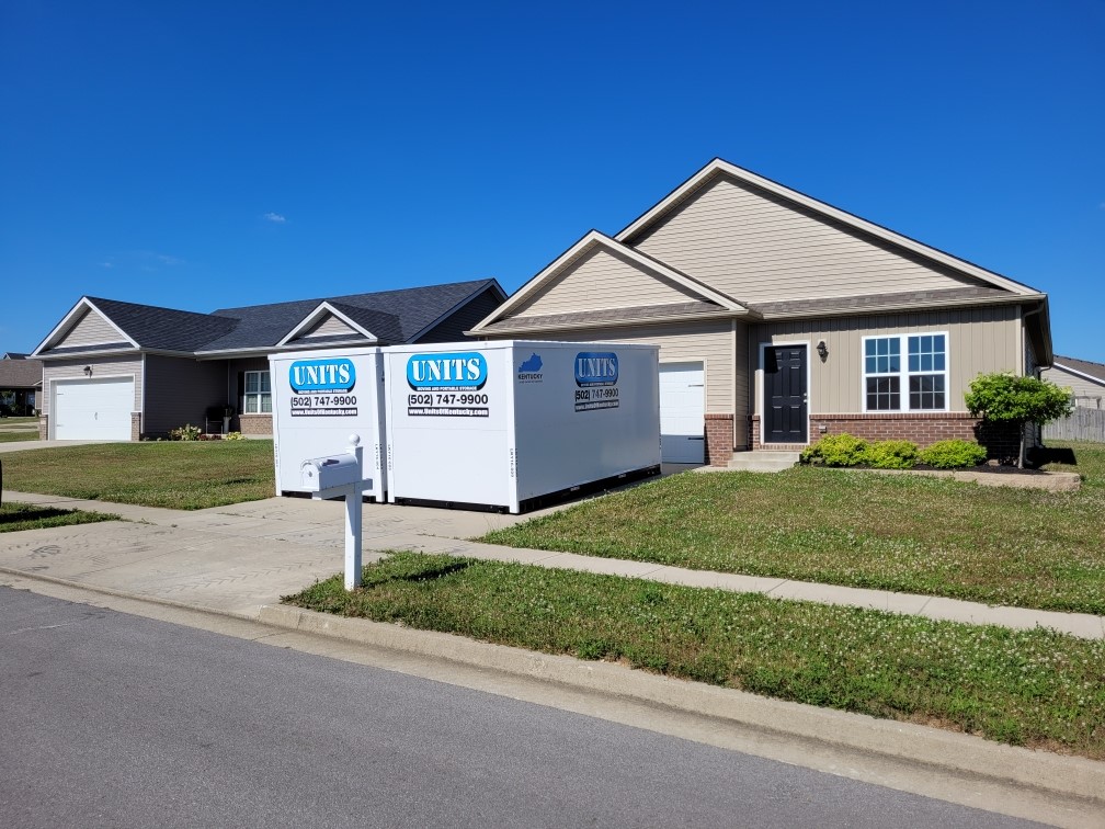 Two Units Of Louisville containers sitting in the driveway of a house.