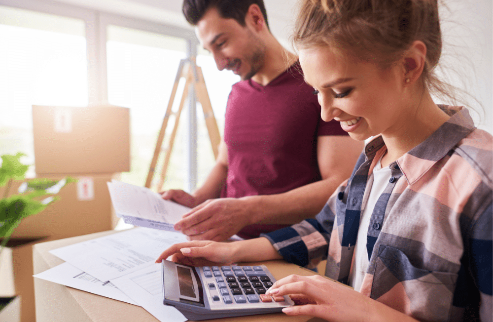 A couple looking at bills using a calculator trying to make a budget.