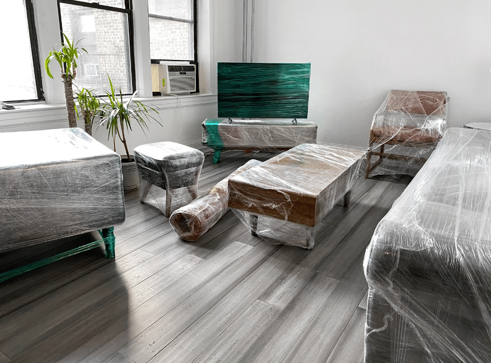 Living room furniture wrapped in plastic wrap.