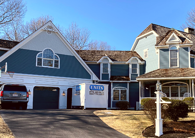 A Units of North Shore container sitting in the driveway of a house.