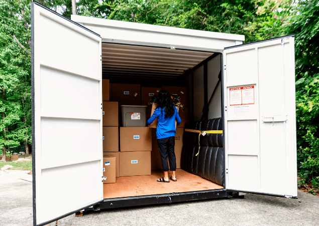 A woman standing inside of a packed container.