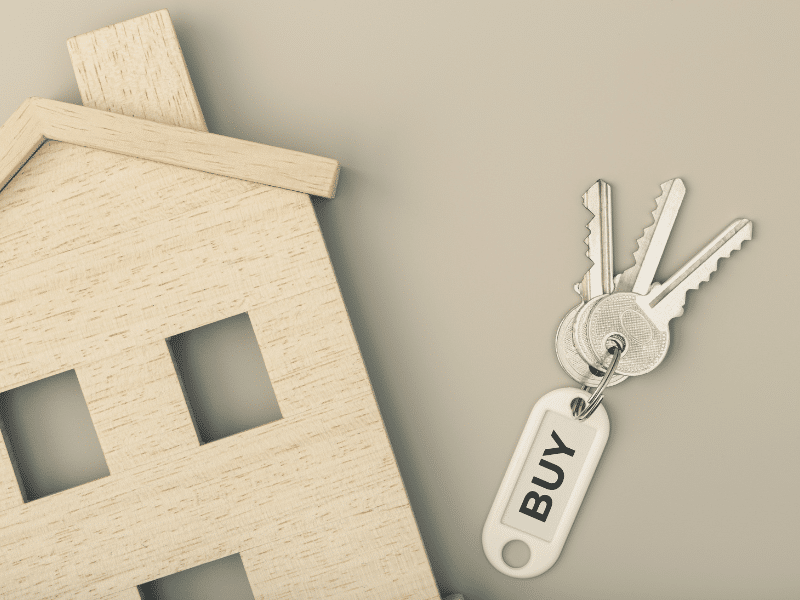 Keys and a wooden house on a table.