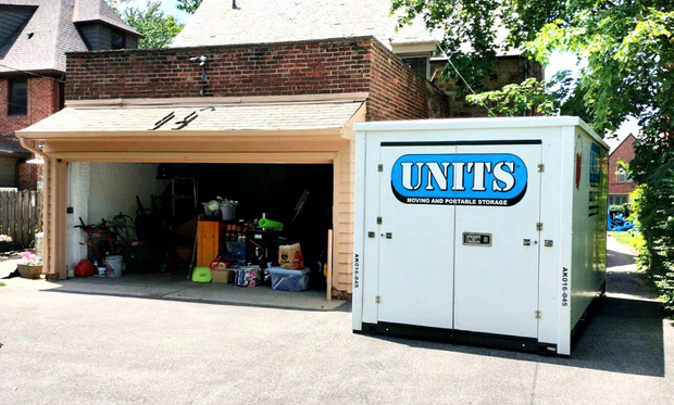 A Units Of Northeast Ohio container sitting in the driveway of a house.