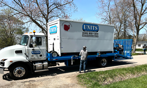 A man standing in front of a Units Of Northeast Ohio truck.