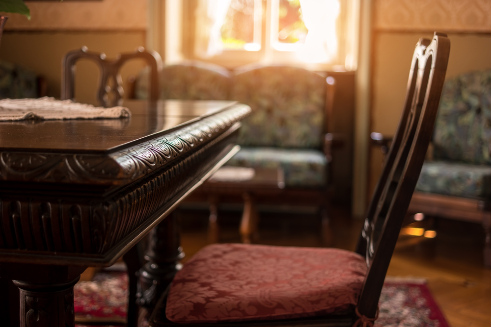 A living room with older furniture and decorated with wood.