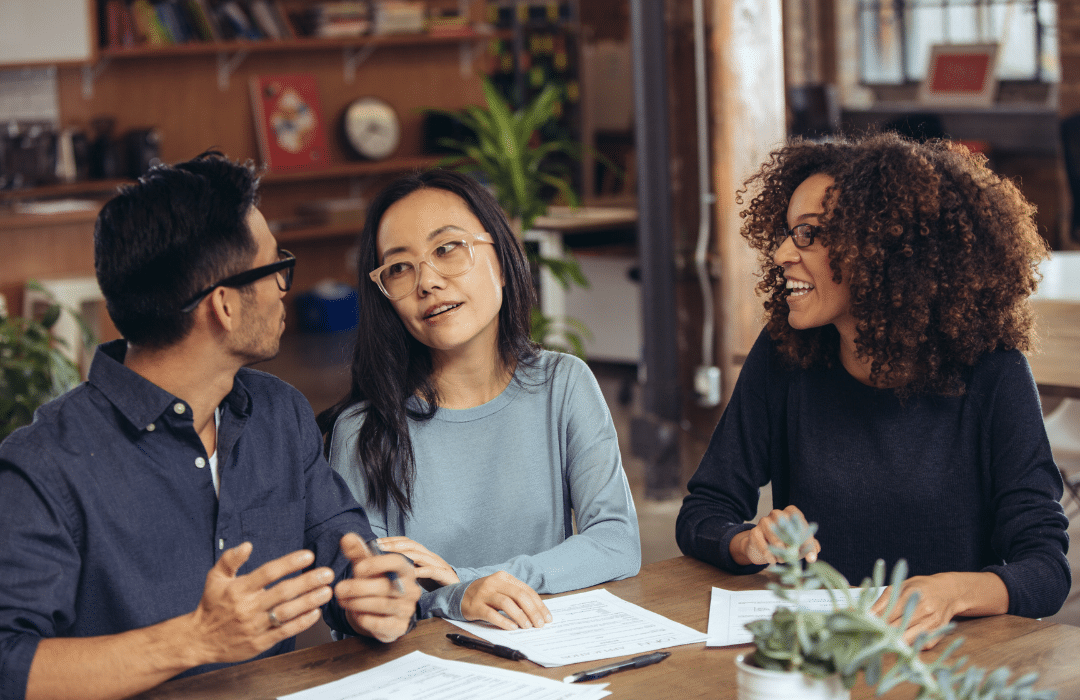 A group of friends talking to each other with papers in front of them.