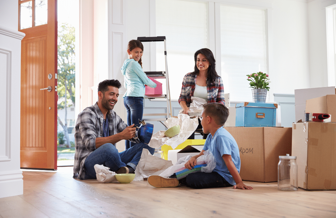 A family unpacking items from boxes in a new house.