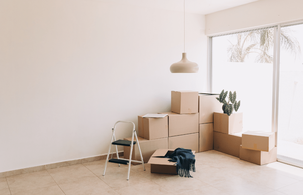 A group of stacked boxes laying in the corner of a room.