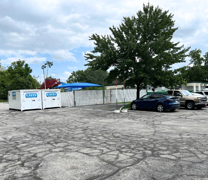 Two Units Of Northeast Ohio containers sitting in a parking lot.