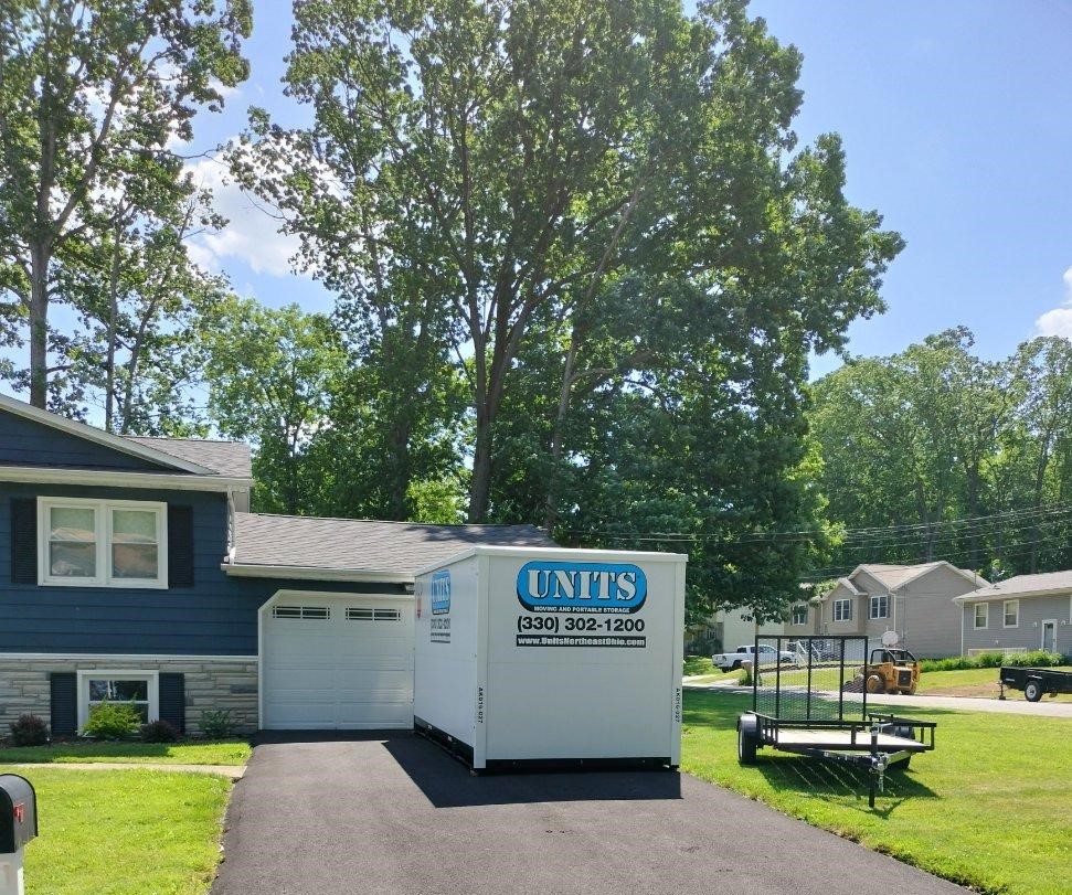 A Units Of Northeast Ohio container sitting in the driveway of a house.