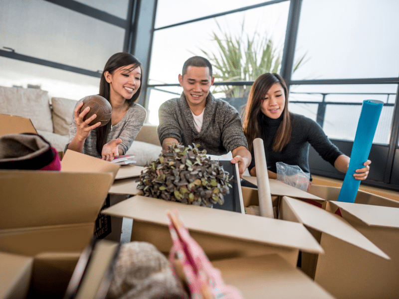 Three people packing boxes with their belongings.