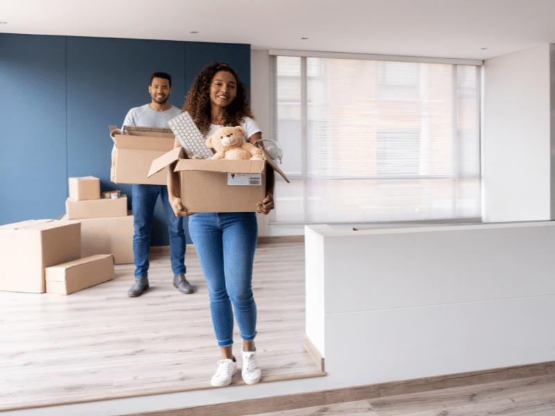 A couple moving boxes of their belongings out of their home.