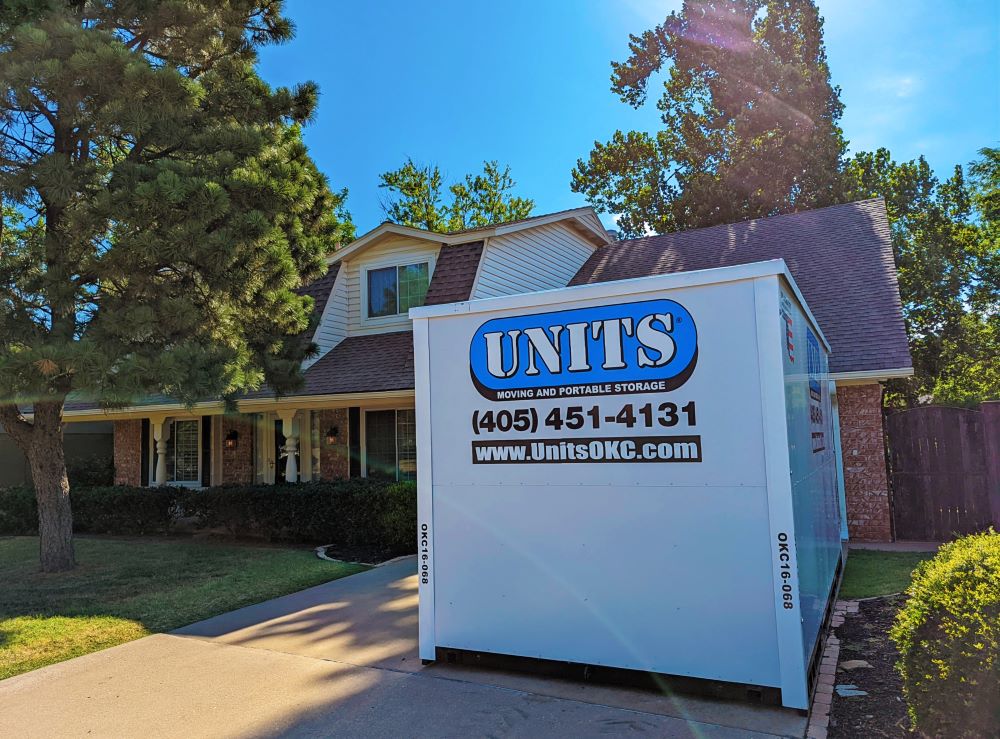 A Units of Oklahoma City container sitting in the driveway of a house.