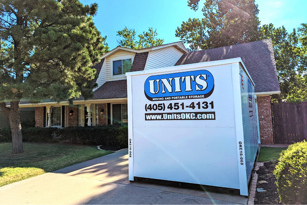 A Units of Oklahoma City container sitting in the driveway of a house.