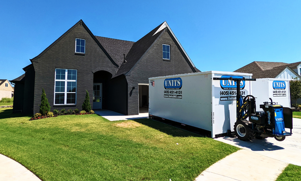 Two Units of Oklahoma City containers sitting in the driveway of a house.