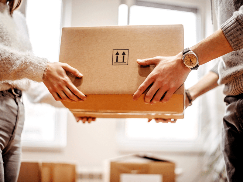 A man handing a woman a box.